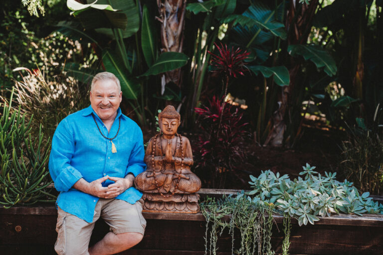 A man sitting on a bench next to a statue.